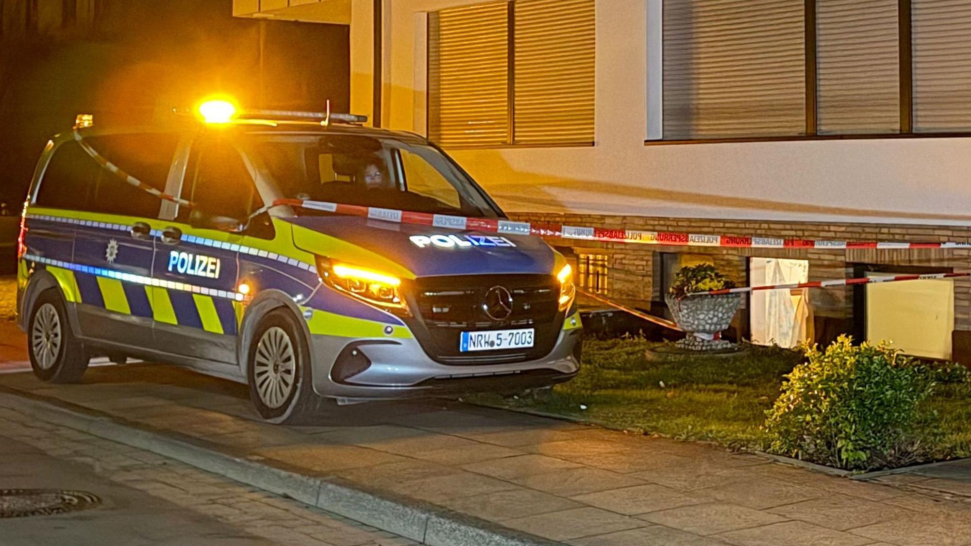 Ein Polizeifahrzeug steht vor einem Haus.