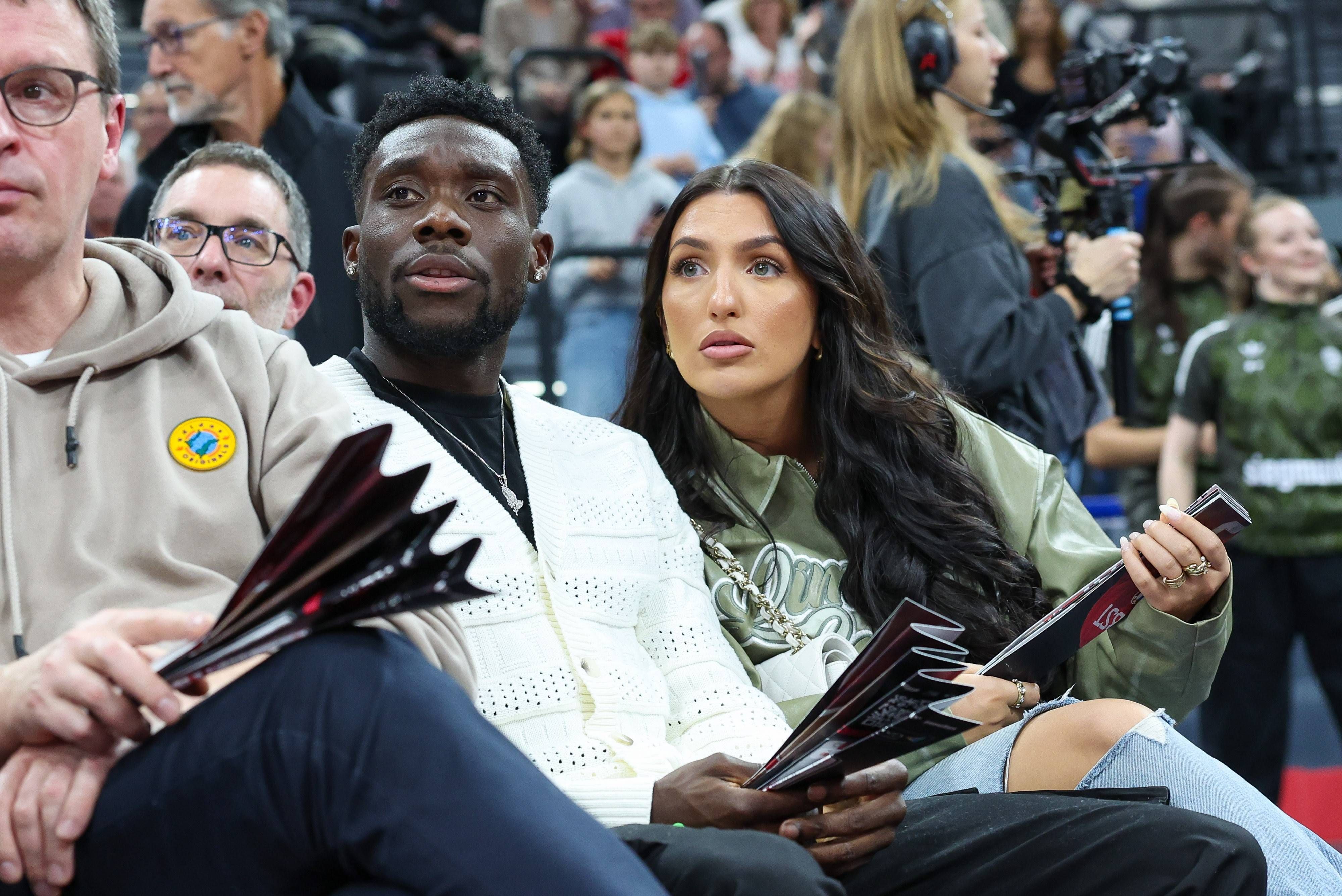 Alphonso Davies und Partnerin Sheyenne als Zuschauer bei einem Basketballspiel.