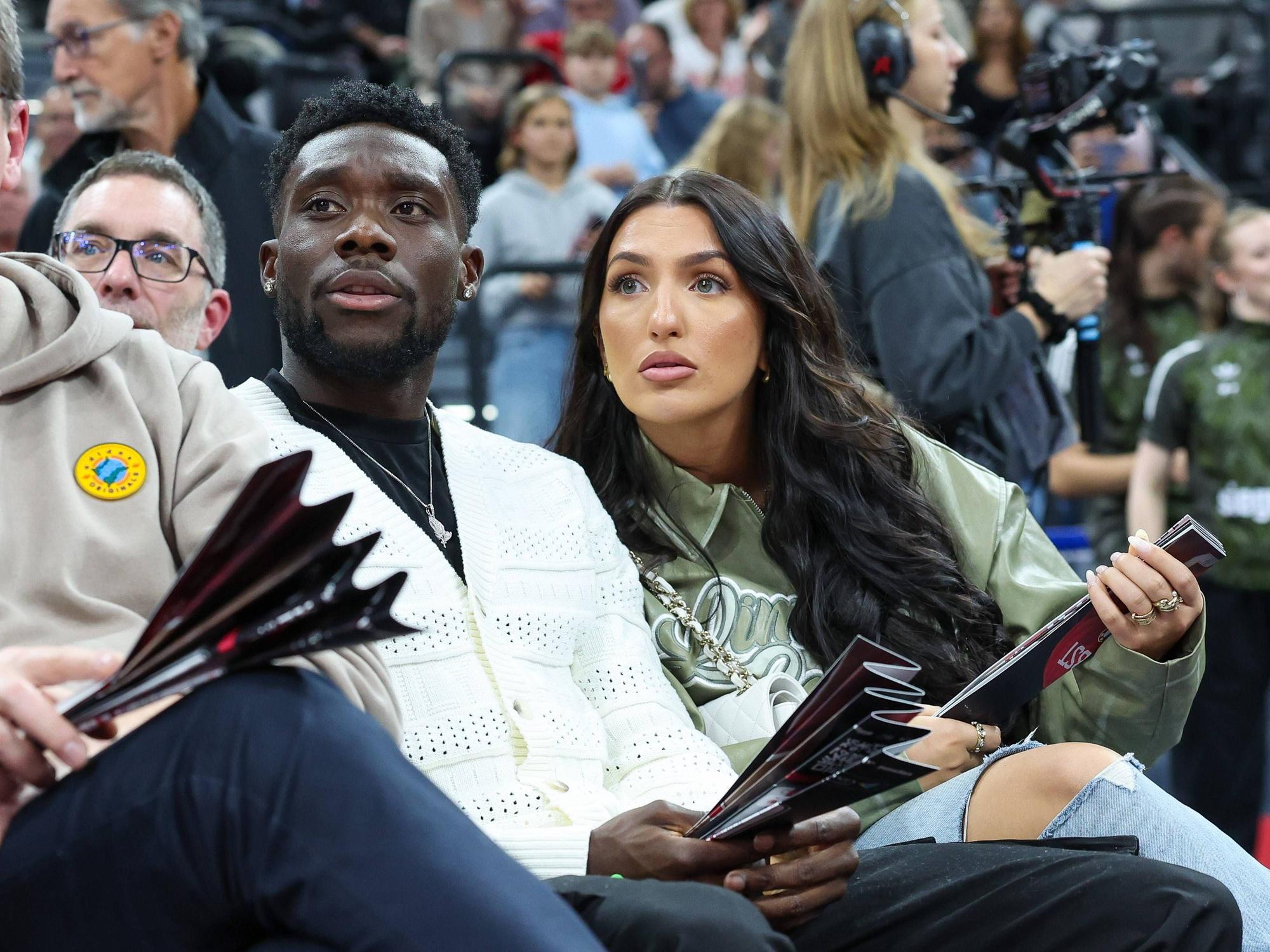 Alphonso Davies und Partnerin Sheyenne als Zuschauer bei einem Basketballspiel.