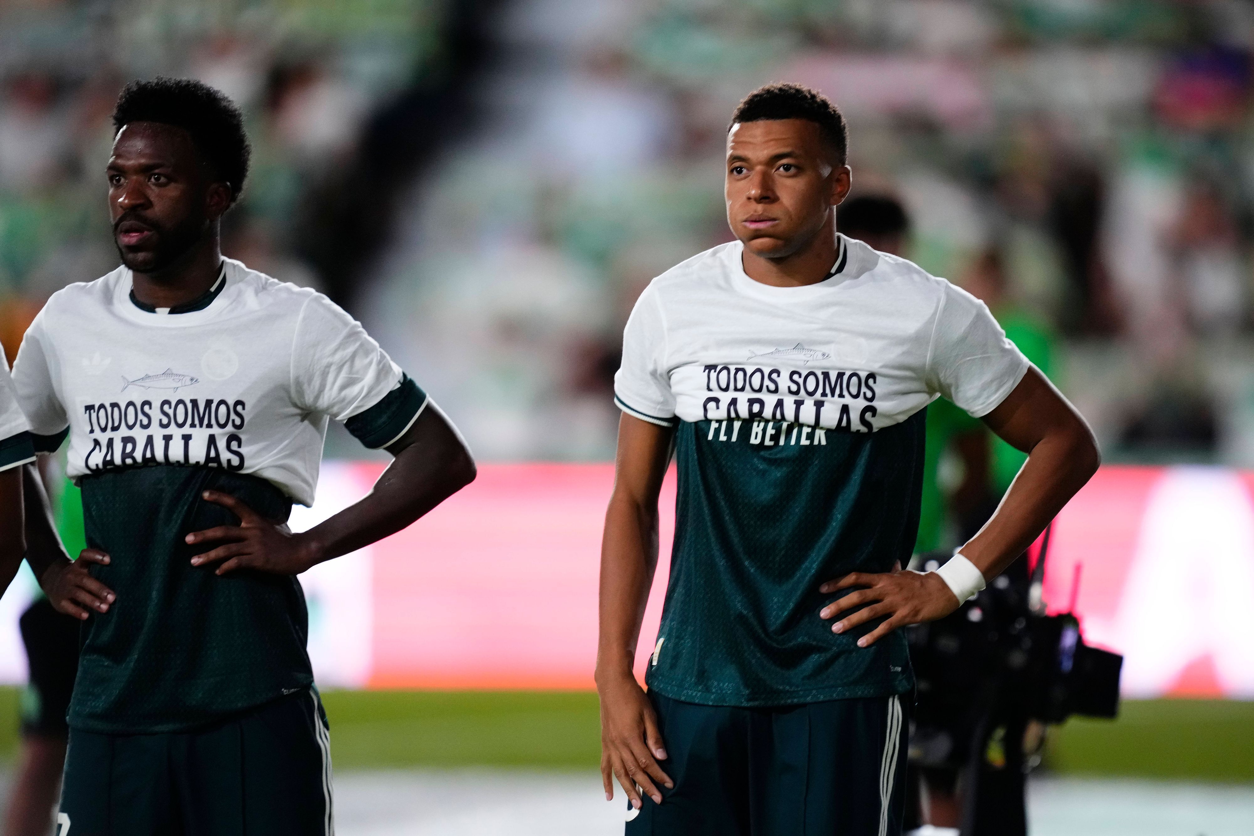 Vinicius Junior und Kylian Mbappé tragen T-Shirts mit einer Botschaft nur bis zur Brust.