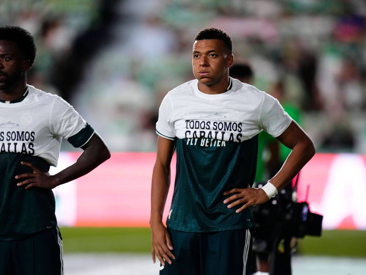 Vinicius Junior und Kylian Mbappé tragen T-Shirts mit einer Botschaft nur bis zur Brust.