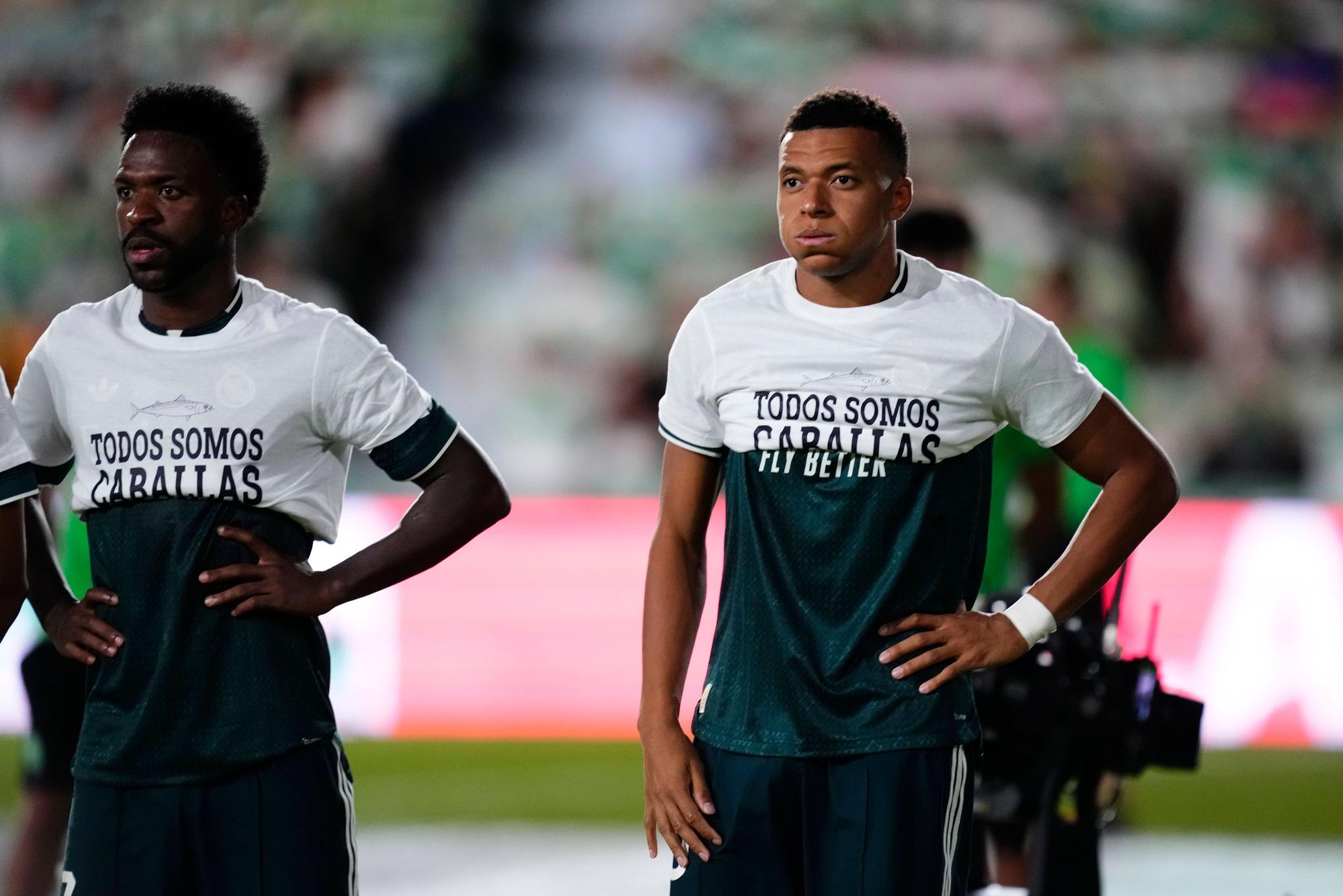 Vinicius Junior und Kylian Mbappé tragen T-Shirts mit einer Botschaft nur bis zur Brust.
