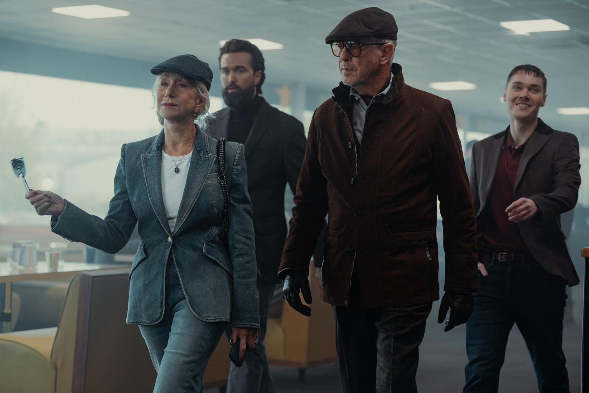 Coole Auftritte können die Harrigans: Maeve (Helen Mirren) und Conrad (Pierce Brosnan, vorne links) mischen mit ihrem Handlanger Paul (Emmett J Scanlan, hinten links) wieder mal einen Laden auf. Pauls Neffe Fergus (Jack Archer) hat seinen ersten Tag und ahnt noch nicht, was gleich passieren wird. (Bild: Paramount +)