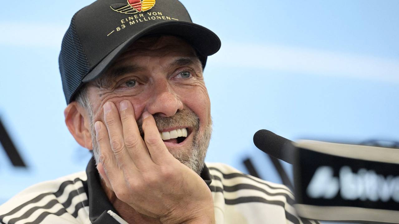 Jürgen Klopp hat den Kopf auf eine Hand abgestützt und lächelt.