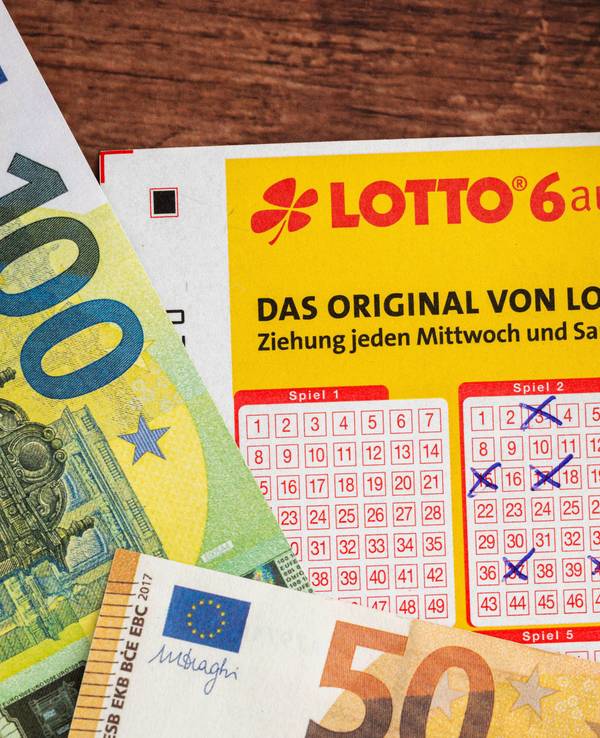Ausgefüllter Lottoschein, Euro-Banknoten und Brille