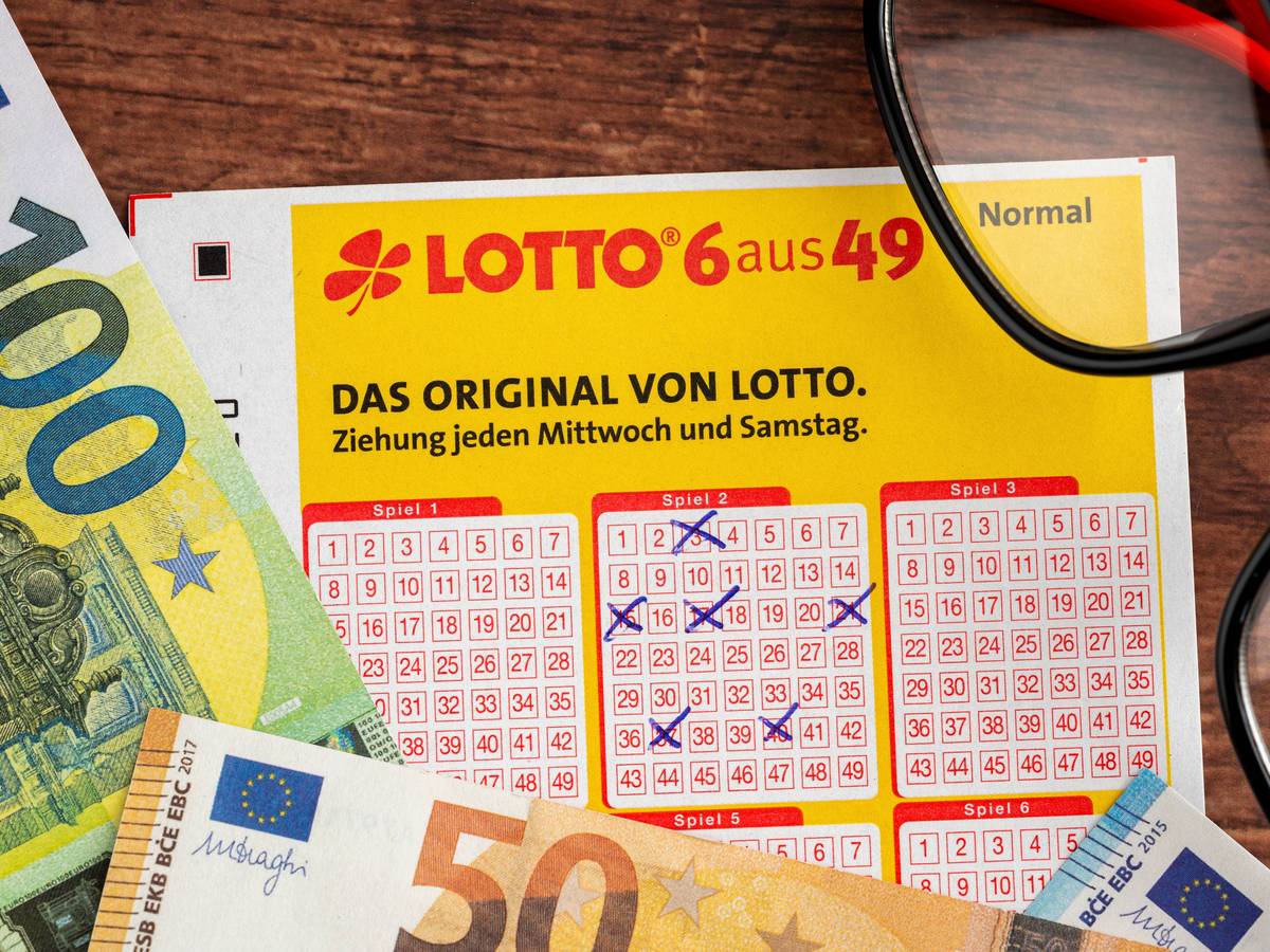Ausgefüllter Lottoschein, Euro-Banknoten und Brille