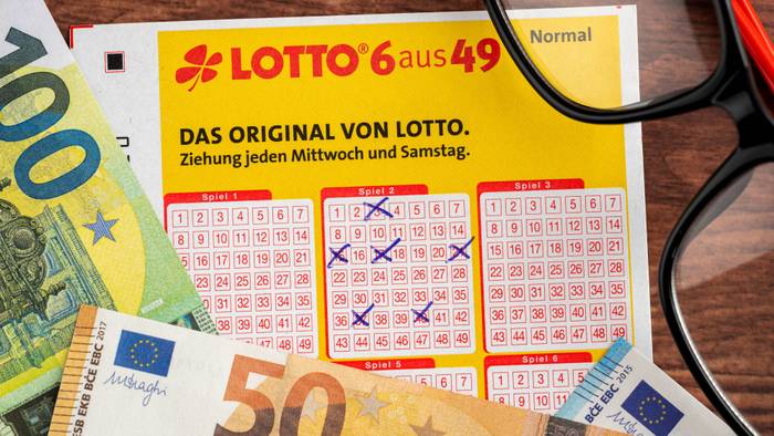 Ausgefüllter Lottoschein, Euro-Banknoten und Brille
