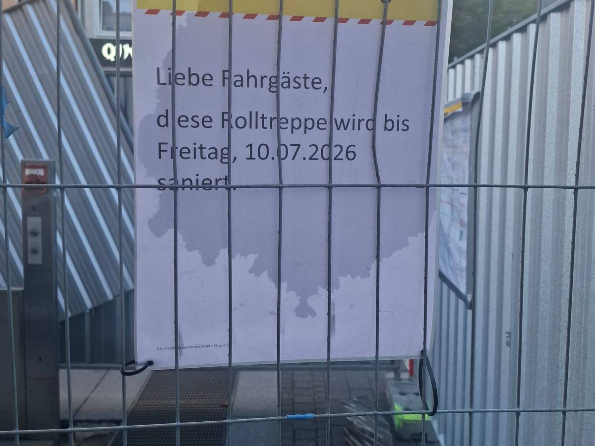 Der Bauzaun an der Haltestelle Piusstraße in Ehrenfeld. Laut Schild sollte die Rolltreppensanierung bereits abgeschlossen sein.