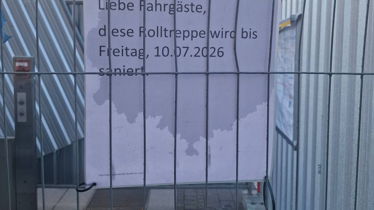 Der Bauzaun an der Haltestelle Piusstraße in Ehrenfeld. Laut Schild sollte die Rolltreppensanierung bereits abgeschlossen sein.