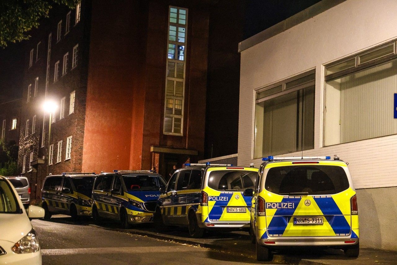 Polizeifahrzeuge stehen bei einem Mehrfamilienhaus.