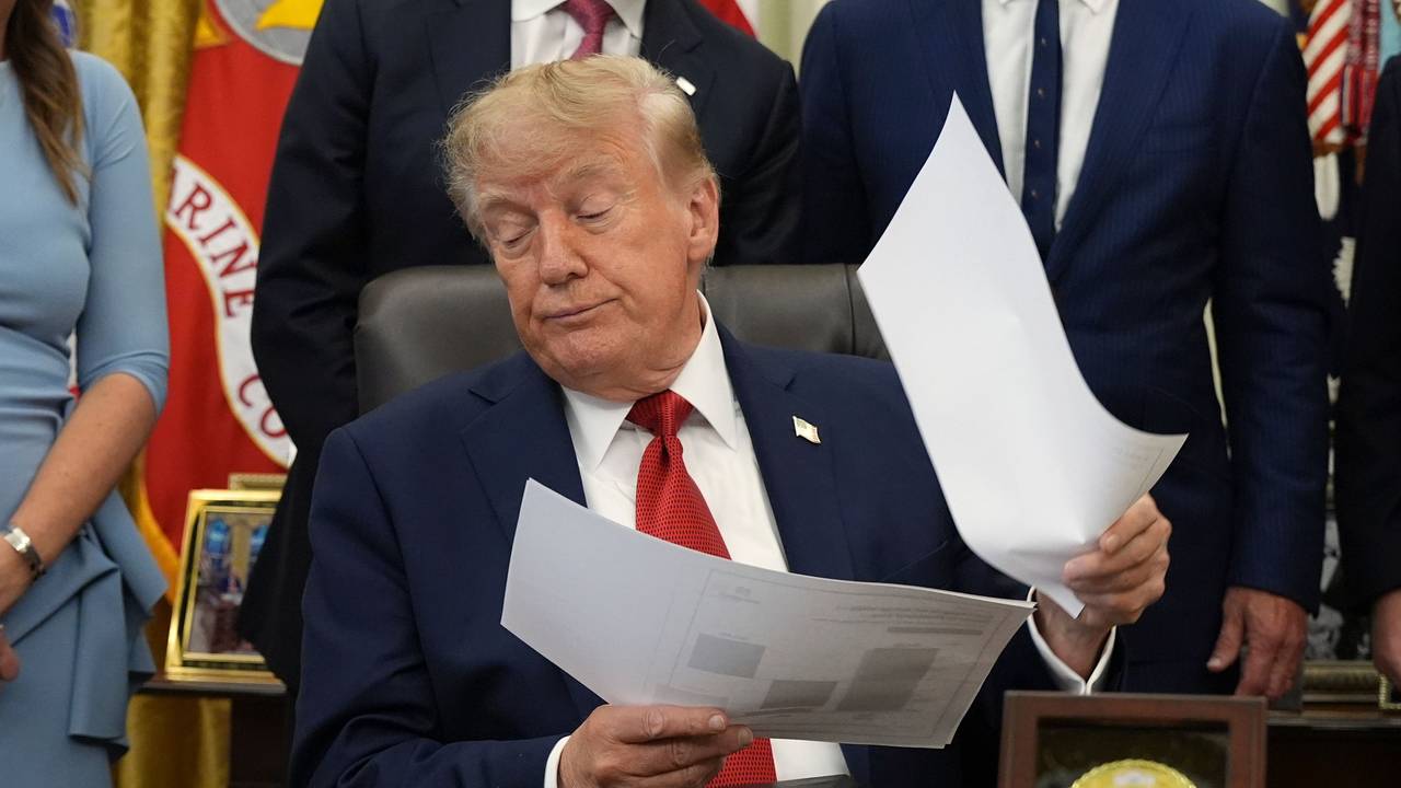 Donald Trump hält Dokumente in der Hand, während er im Oval Office des Weißen Hauses über das Gesundheitswesen spricht.