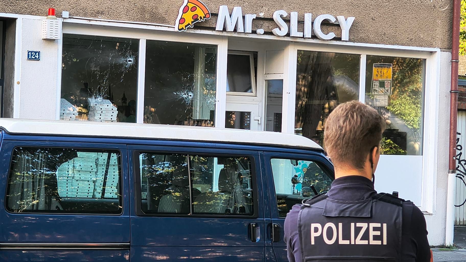 Die Polizei ist am Freitagmorgen in Köln-Mülheim im Einsatz. Zuvor hatte es Schüsse auf ein Wohnhaus mit Pizzeria im Erdgeschoss gegeben.