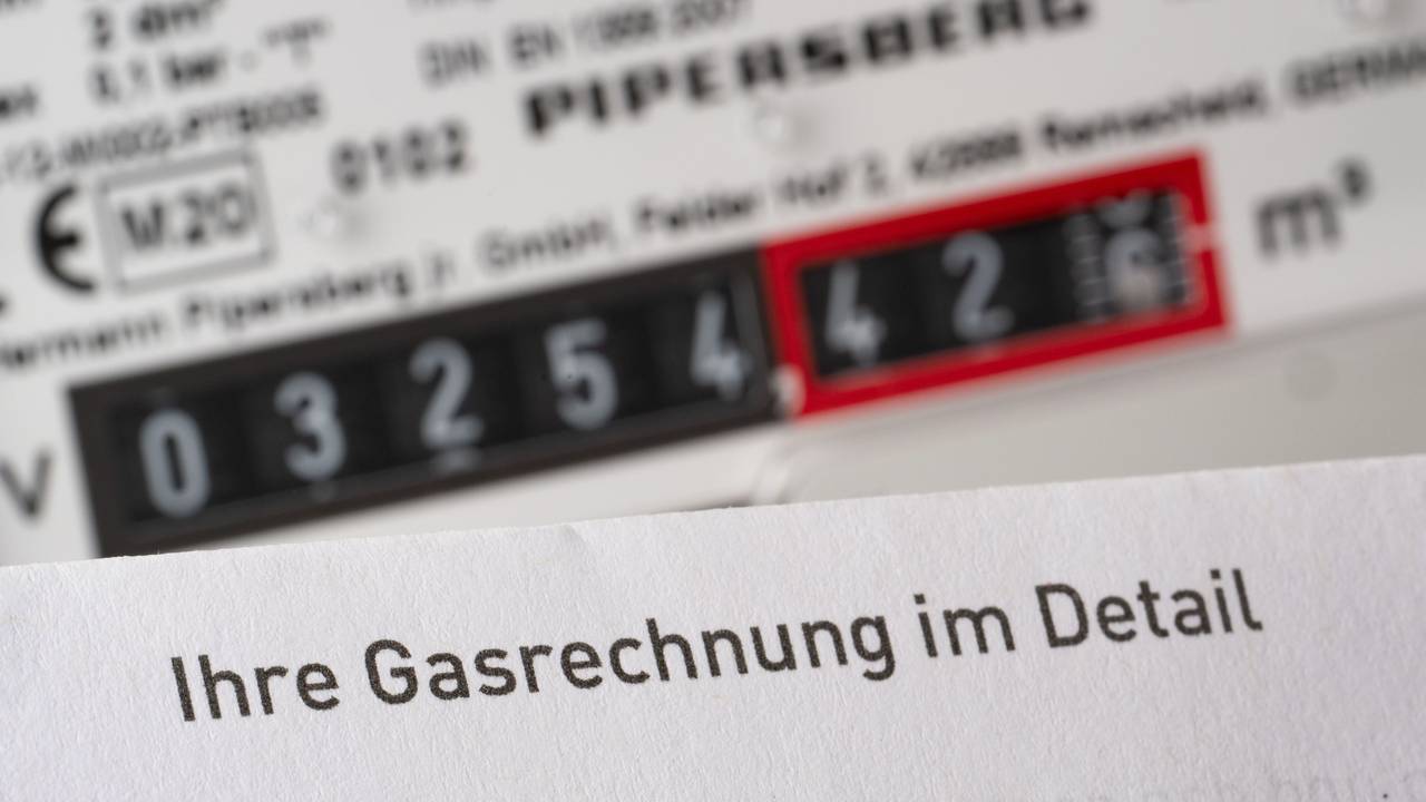 Eine Gasrechnung wird in einem privaten Haushalt vor einem Gaszähler gehalten (Symbolbild).