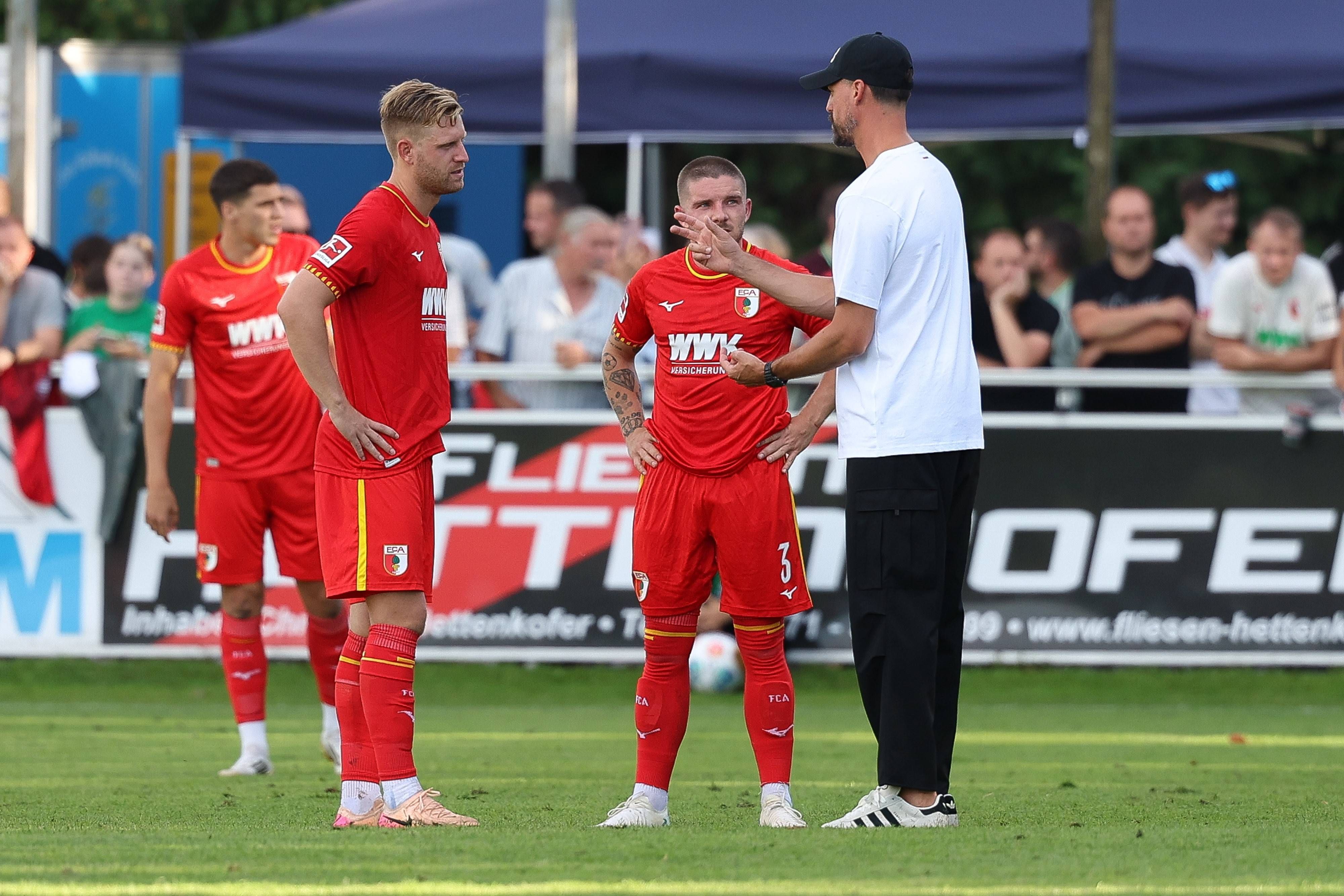 Sandro Wagner erklärt Mads Pedersen und Arne Maier etwas auf dem Platz.