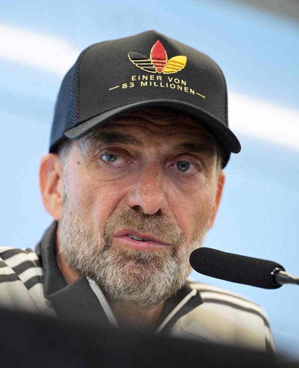 Jürgen Klopp mit Adidas-Deutschland-Mütze auf einer Pressekonferenz.