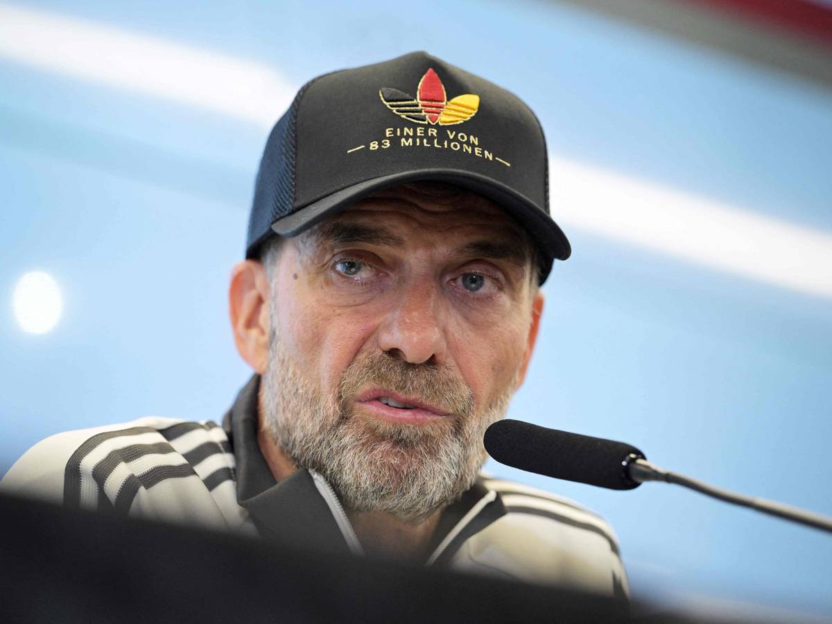 Jürgen Klopp mit Adidas-Deutschland-Mütze auf einer Pressekonferenz.