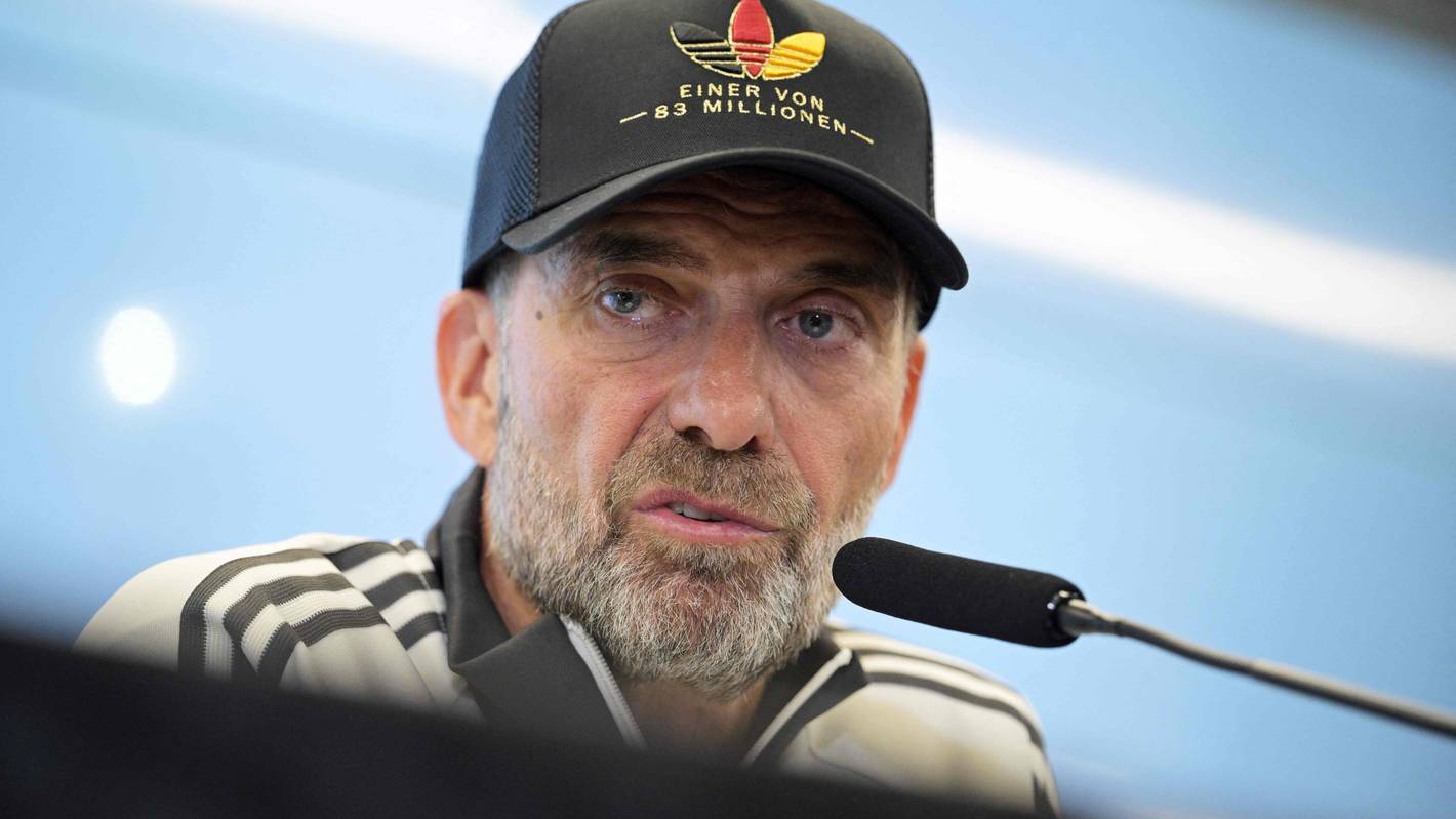 Jürgen Klopp mit Adidas-Deutschland-Mütze auf einer Pressekonferenz.