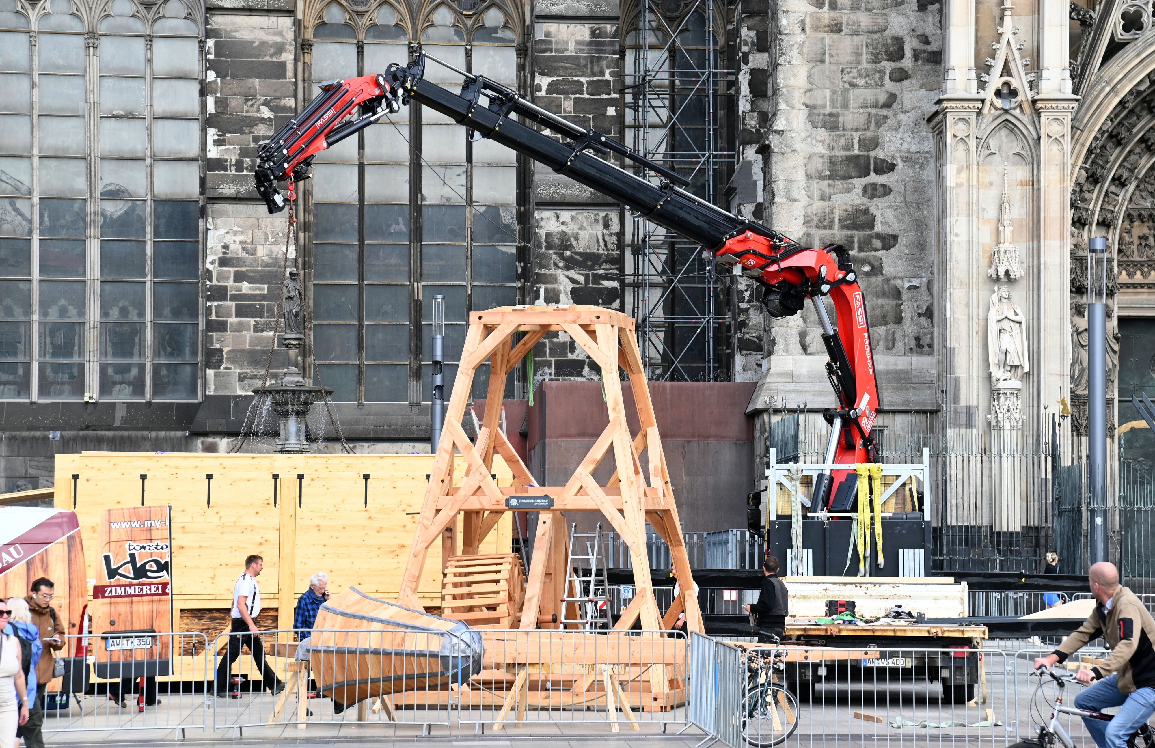 Auf dem Roncalliplatz wird ein hölzerner Kran aufgebaut, wie er zum Bau des Doms benutzt wurde.