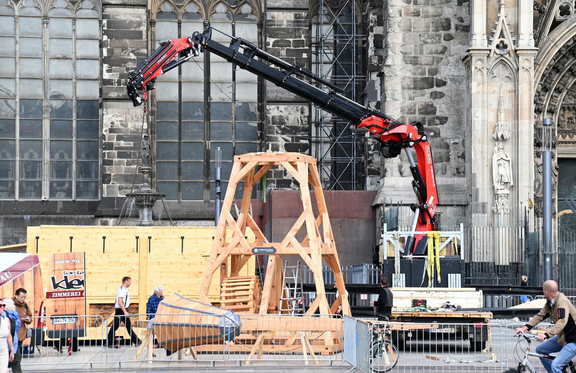Auf dem Roncalliplatz wird ein hölzerner Kran aufgebaut, wie er zum Bau des Doms benutzt wurde.