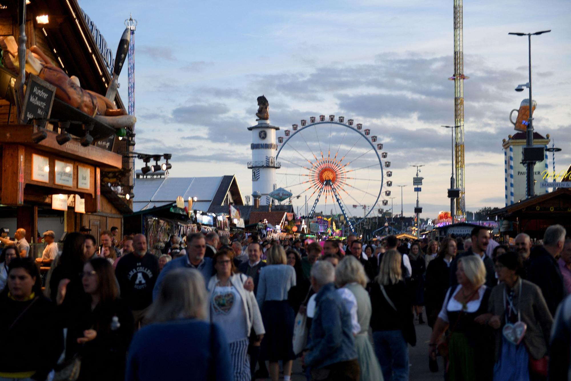 Wiesngäste gehen über das Oktoberfest.