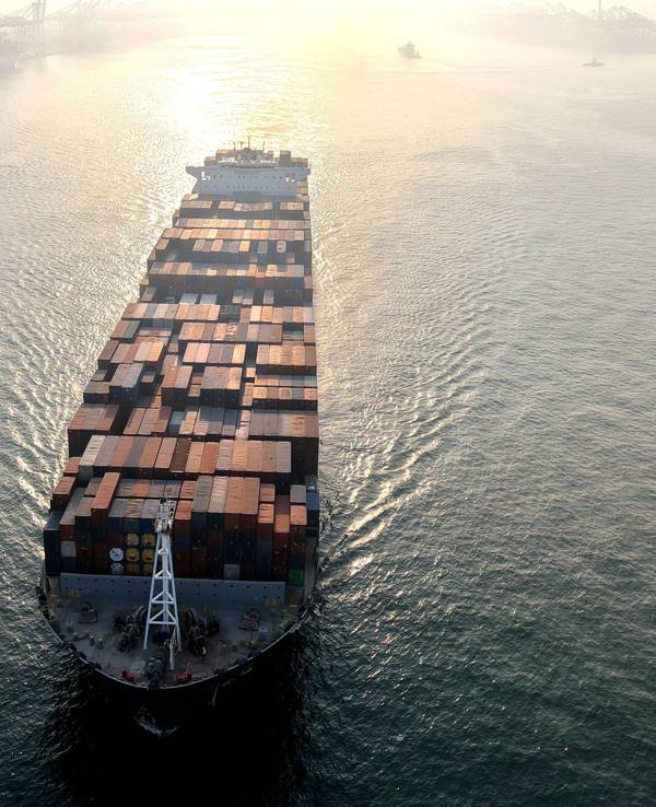 Ein Containerschiff fährt in einen Hafen.