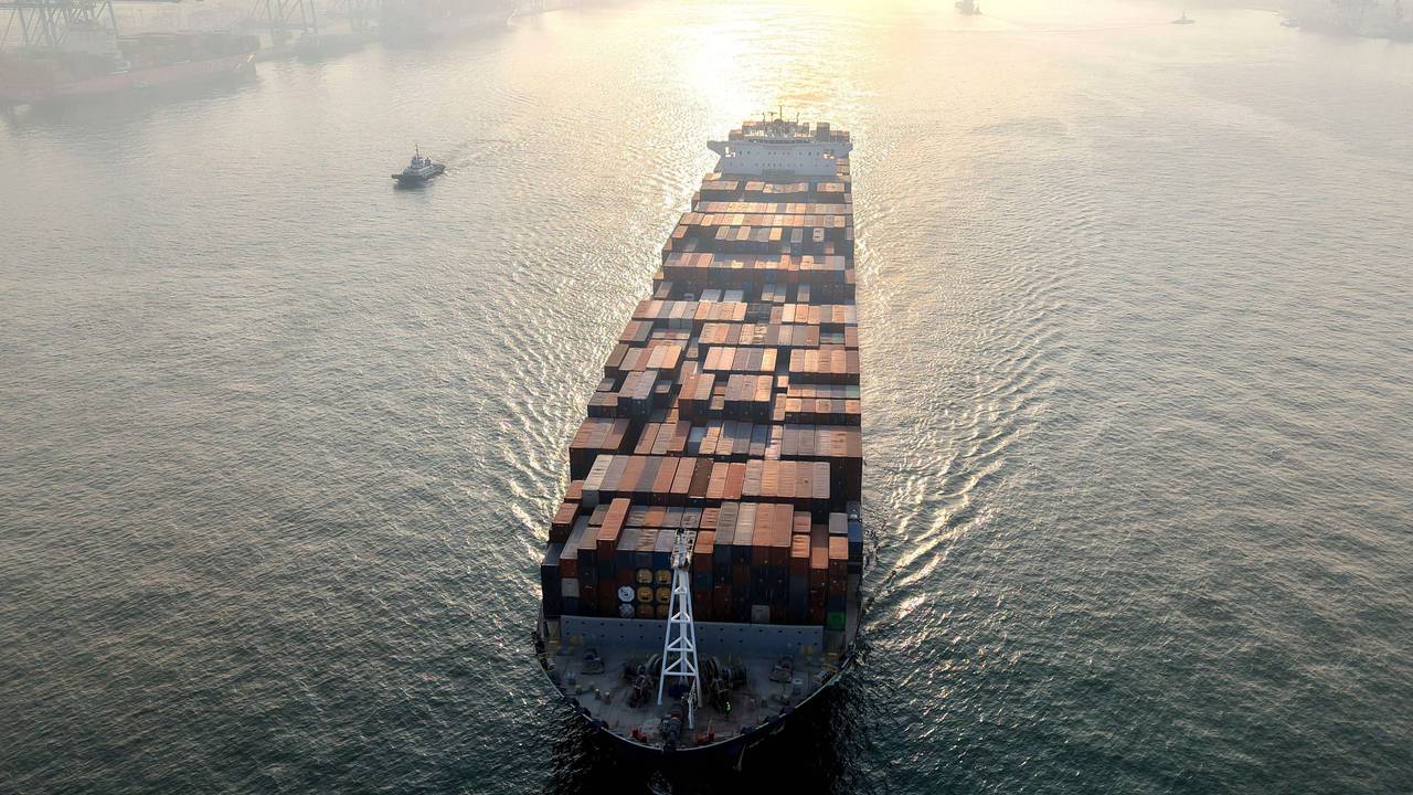 Ein Containerschiff fährt in einen Hafen.