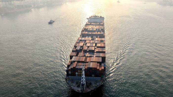 Ein Containerschiff fährt in einen Hafen.