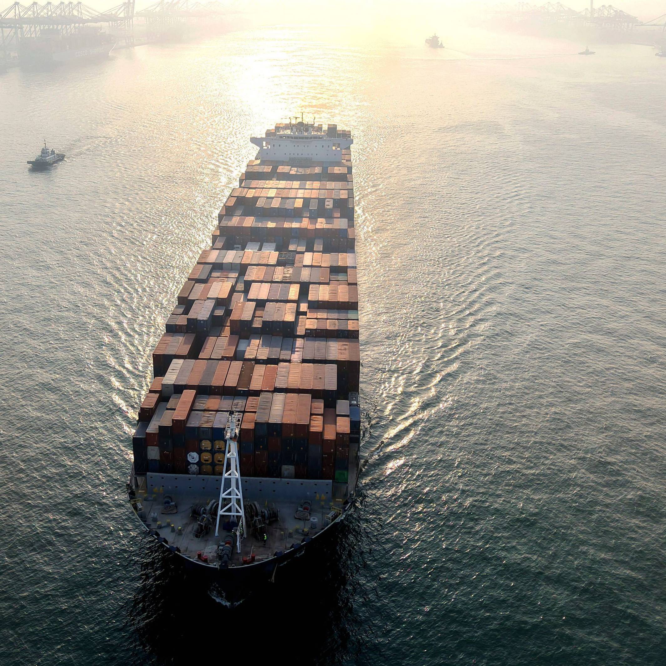 Ein Containerschiff fährt in einen Hafen.