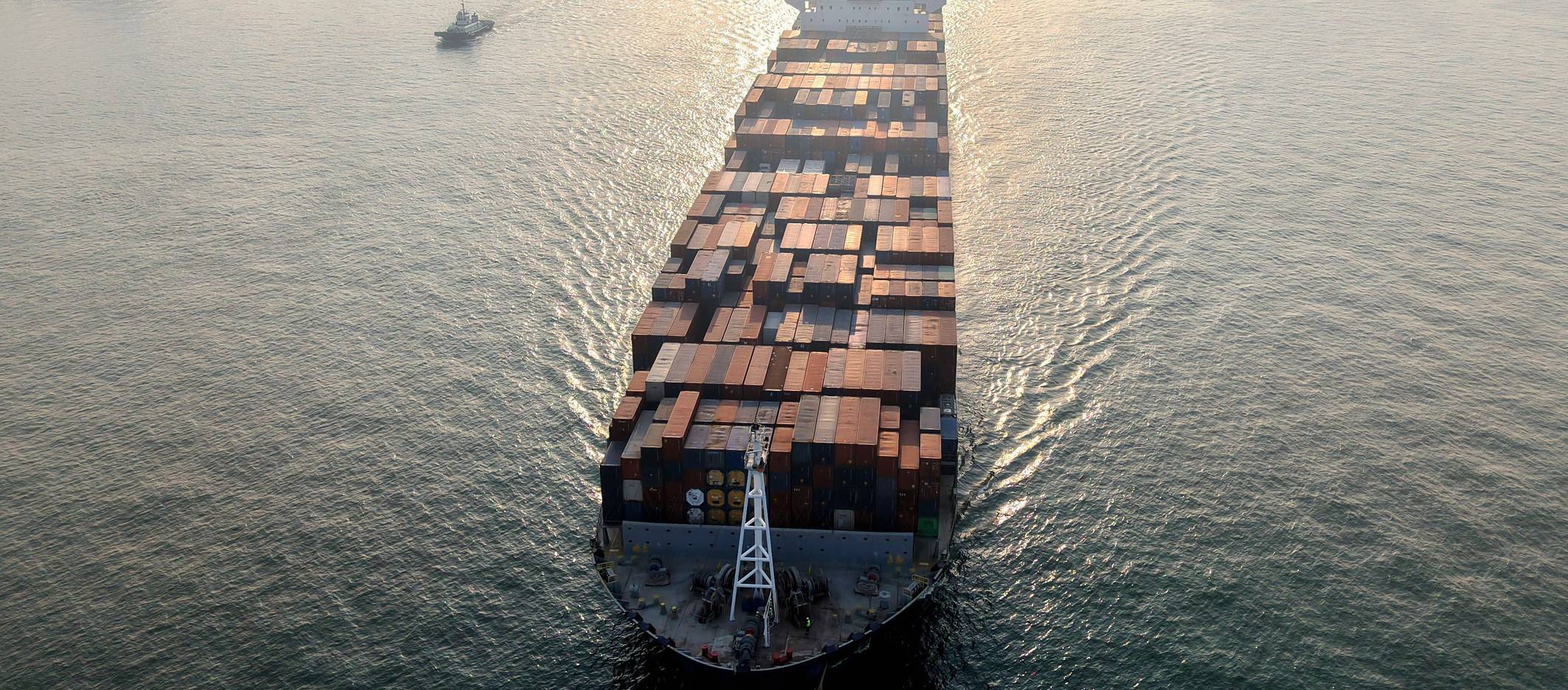 Ein Containerschiff fährt in einen Hafen.