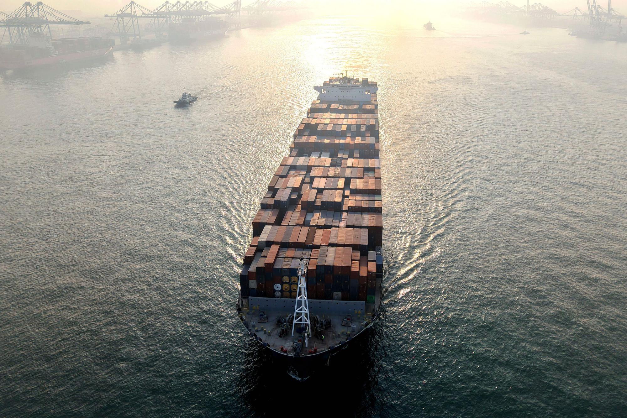 Ein Containerschiff fährt in einen Hafen.