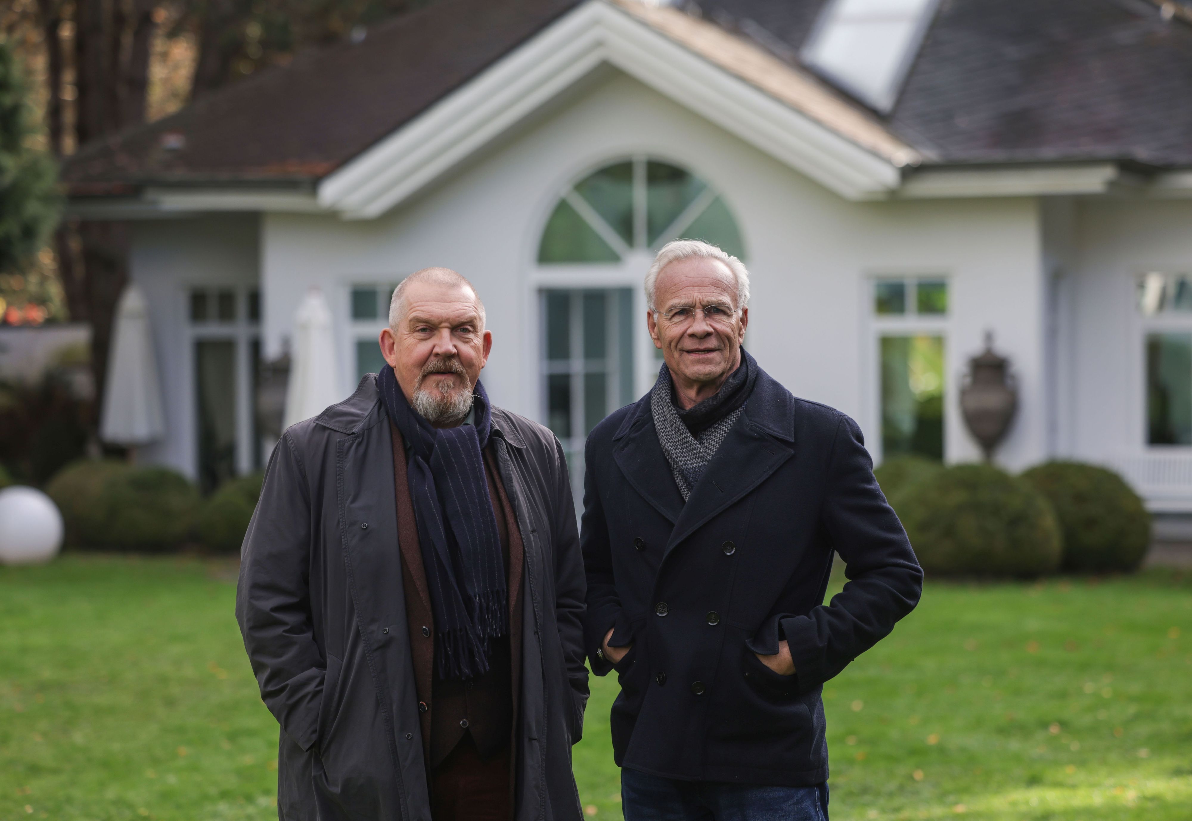 17.11.2025, Nordrhein-Westfalen, Köln: Die Schauspieler Klaus J. Behrendt (r, als Max Ballauf) und Dietmar Bär (als Freddy Schenk) stehen am Drehort im Garten einer Villa. Unter dem Titel «Der Glücklichmacher» drehen die Kölner Tatort-Kommissare Ballauf und Schenk im Kölner Villenviertel Hahnwald. Foto: Oliver Berg/dpa +++ dpa-Bildfunk +++