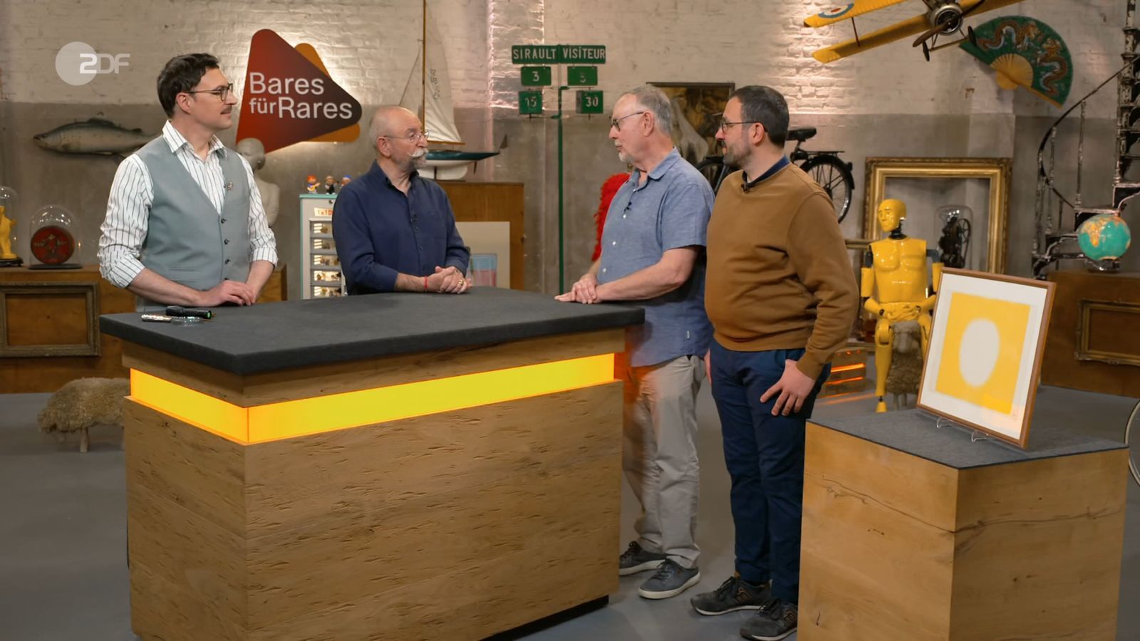 Colmar Schulte-Goltz (links) klärt Horst Lichter (Zweiter von links) sowie die Kandidaten Helmut und Julian (rechts) über das Bild mit dem Titel „Gelb“ auf. (Bild: ZDF)