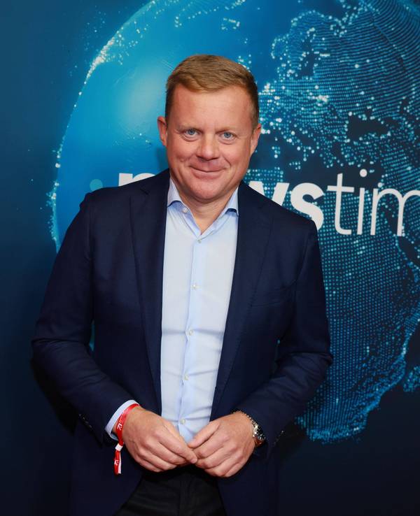 Marc Bator lächelt vor Newstime-Hintergrund