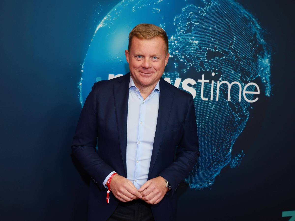Marc Bator lächelt vor Newstime-Hintergrund