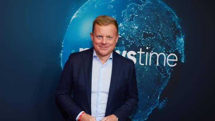 Marc Bator lächelt vor Newstime-Hintergrund