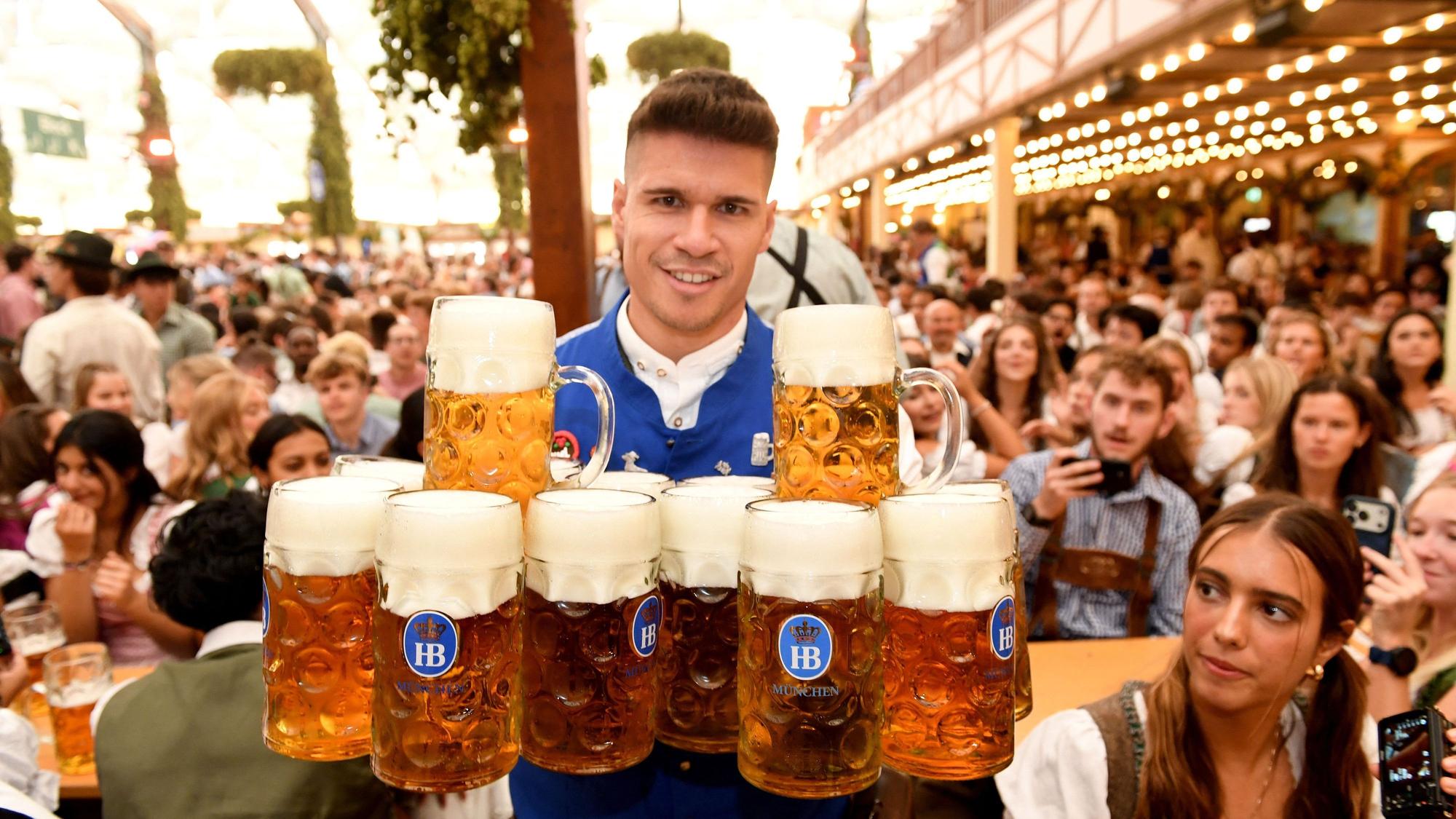 Eine Bedienung bring im Hofbräuzelt nach dem Anstich Bier zu den Gästen