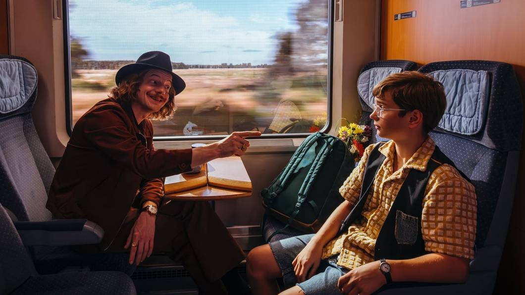 Emil (Nicholas Jonah Peter, rechts) trifft im Zug auf den schmierigen Ganoven Max Grundeis (Merlin Sandmeyer) - eine Begegnung, die er noch bereuen wird. (Bild: Warner Bros. Film Productions Germany/UFA Fiction/UFA Mitte/Xiomara Bender)