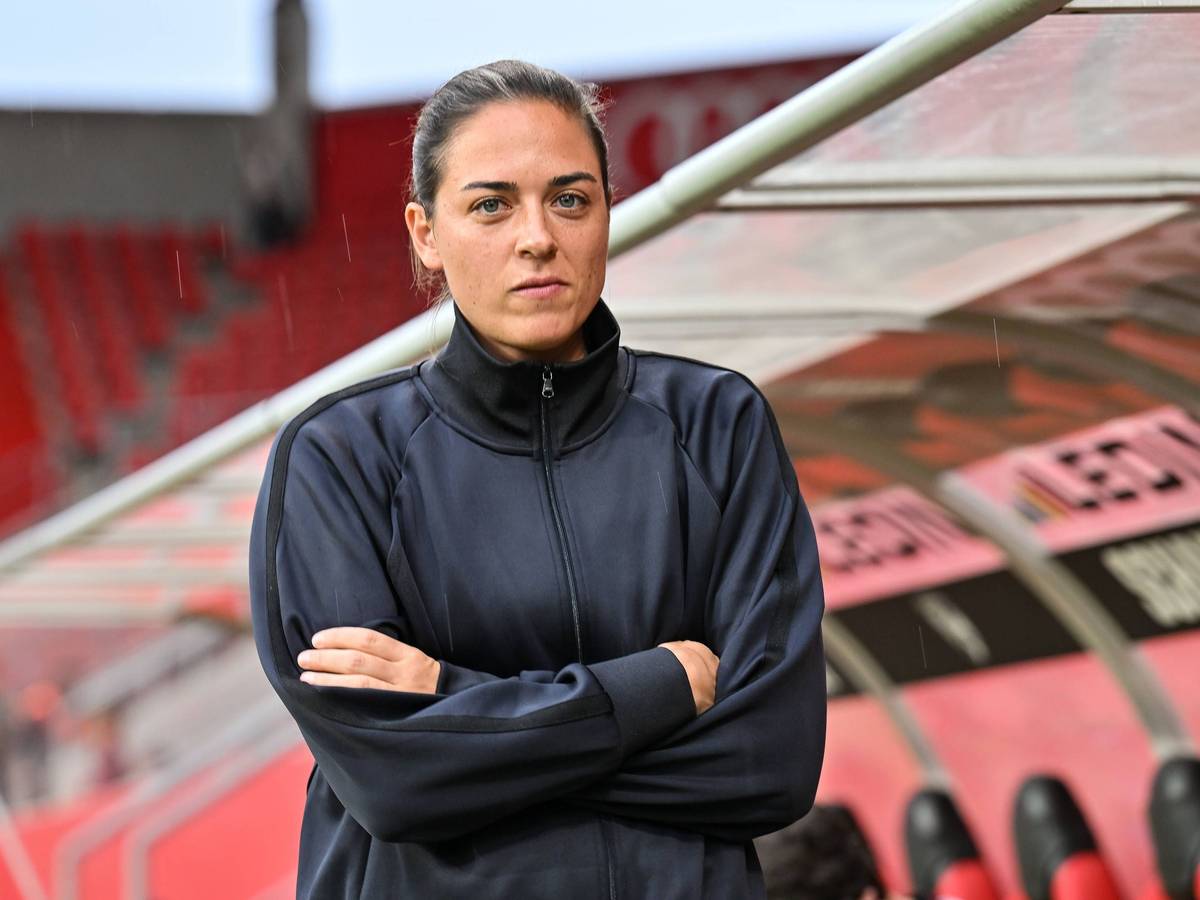 Sabrina Wittmann mit verschränkten Armen vor der Trainerbank.