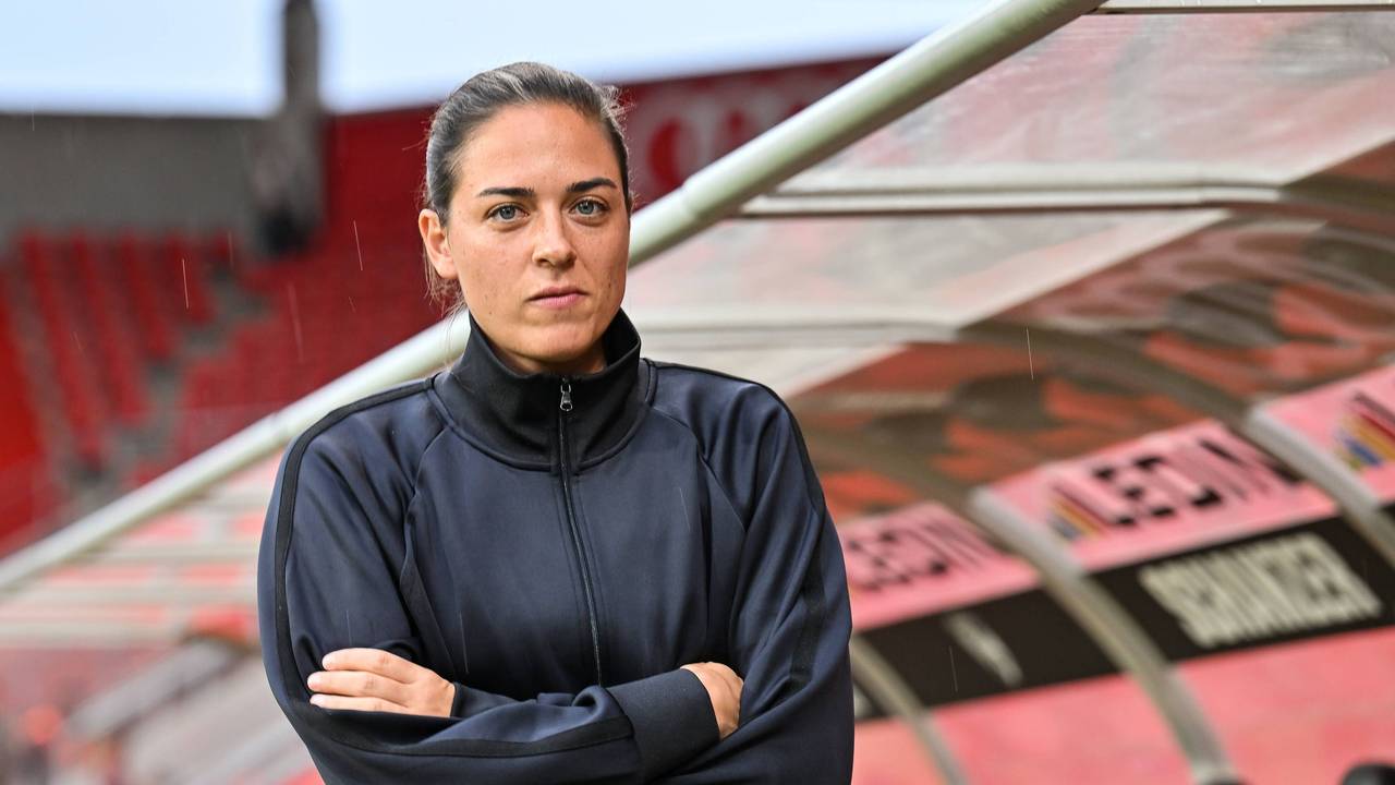 Sabrina Wittmann mit verschränkten Armen vor der Trainerbank.