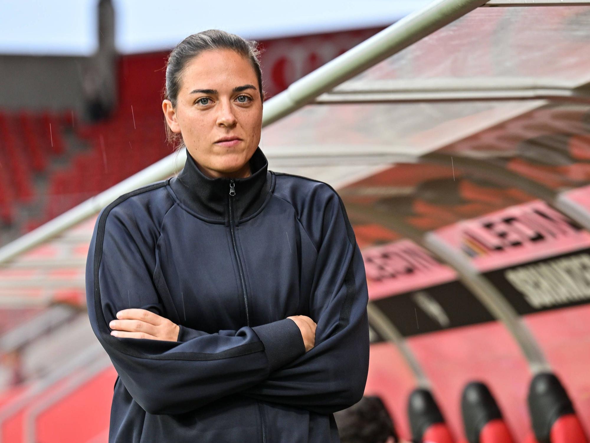 Sabrina Wittmann mit verschränkten Armen vor der Trainerbank.