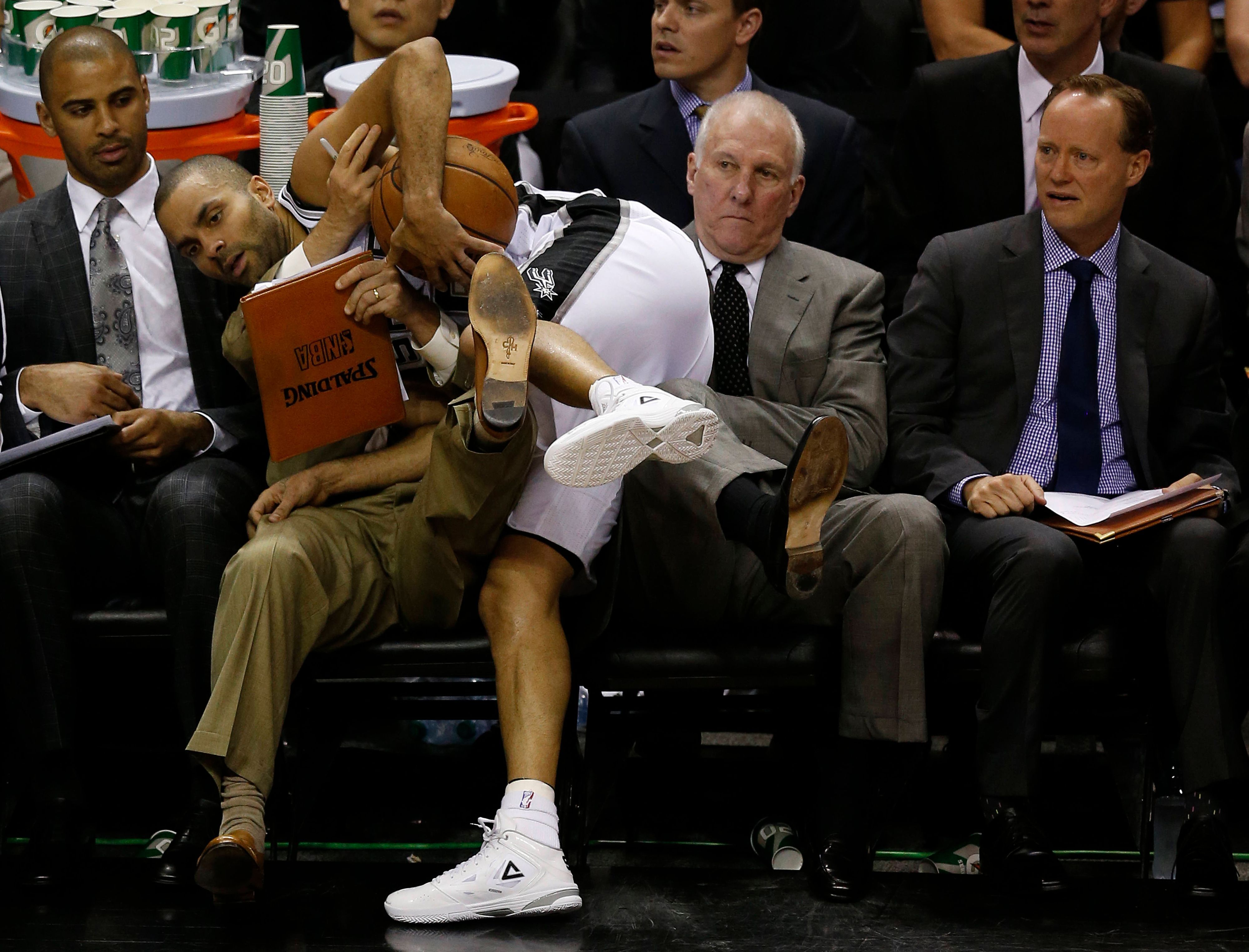 Tony Parker landet am Spielfeldrand auf Gregg Popovich. Dessen Assistent Mike Budenholzer