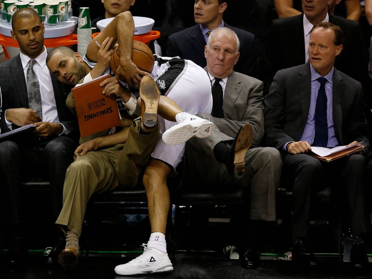 Tony Parker landet am Spielfeldrand auf Gregg Popovich. Dessen Assistent Mike Budenholzer