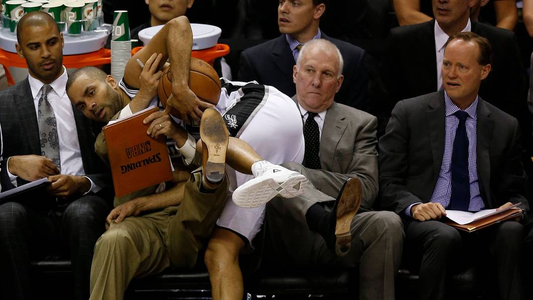Tony Parker landet am Spielfeldrand auf Gregg Popovich. Dessen Assistent Mike Budenholzer
