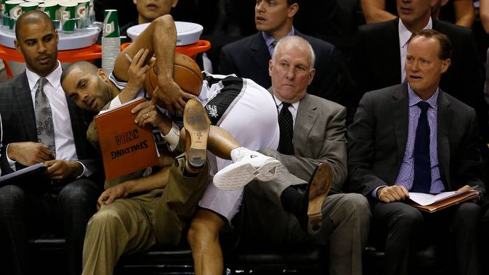 Tony Parker landet am Spielfeldrand auf Gregg Popovich. Dessen Assistent Mike Budenholzer