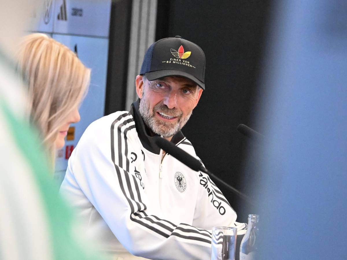 Jürgen Klopp guckt bei einer Pressekonferenz zur DFB-Pressesprecherin.