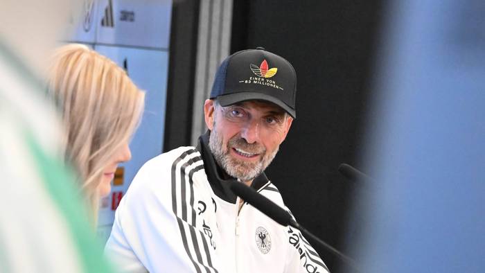 Jürgen Klopp guckt bei einer Pressekonferenz zur DFB-Pressesprecherin.
