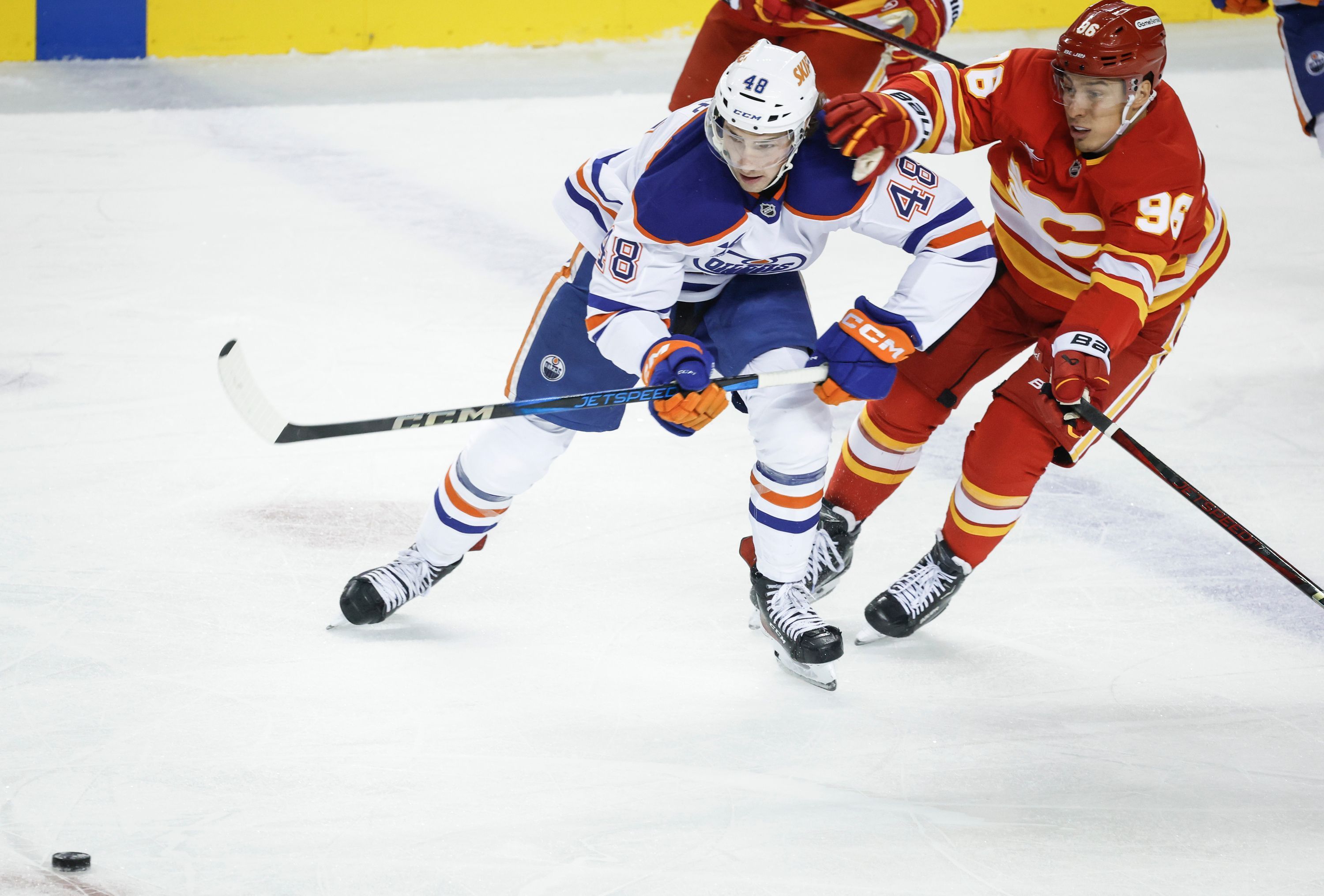 Noah Philp (links) von den Edmonton Oilers wird von Andrei Kusmenko (rechts) von den Calgary Flames festgehalten.