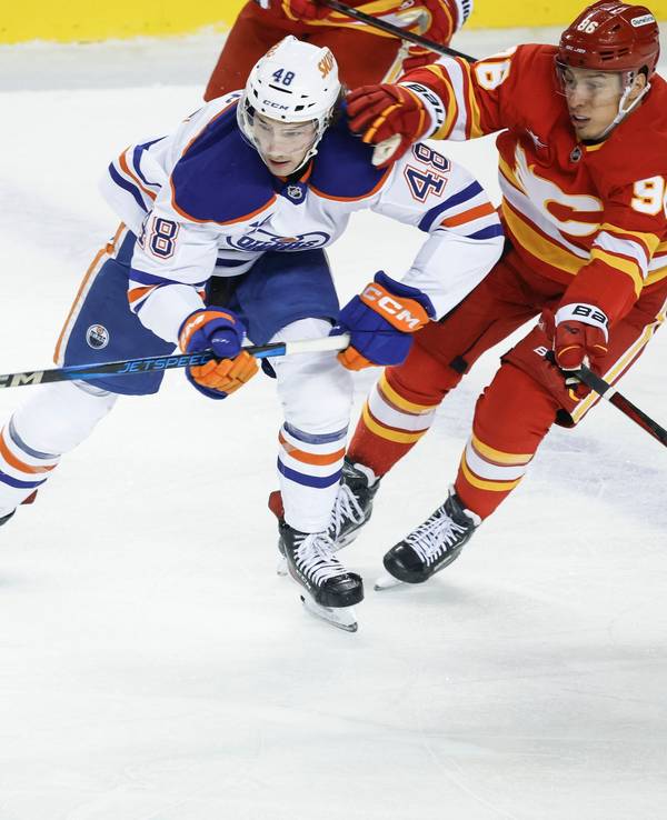 Noah Philp (links) von den Edmonton Oilers wird von Andrei Kusmenko (rechts) von den Calgary Flames festgehalten.