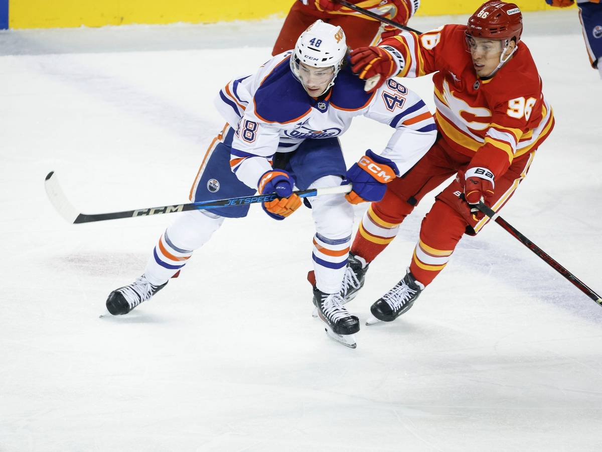 Noah Philp (links) von den Edmonton Oilers wird von Andrei Kusmenko (rechts) von den Calgary Flames festgehalten.