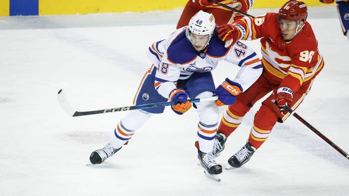 Noah Philp (links) von den Edmonton Oilers wird von Andrei Kusmenko (rechts) von den Calgary Flames festgehalten.